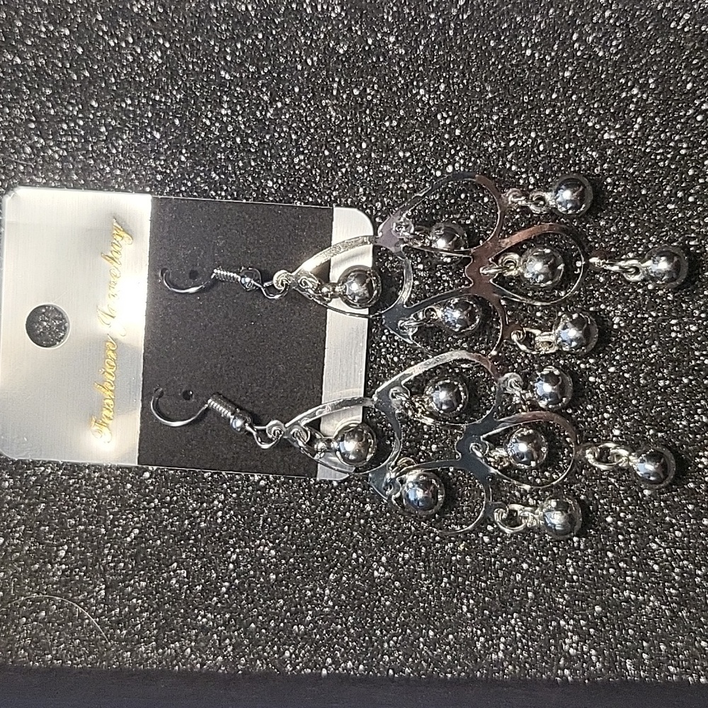 Silver chandelier earrings with balls.